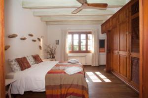 a bedroom with a bed and a ceiling fan at Charming villa by the sea in Llucmajor +30 photos