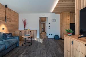 a living room with a couch and a table at Arnica Alpin Lodge 1 in Cavedago