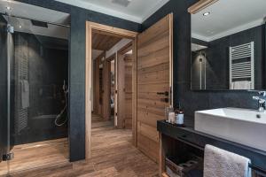 a bathroom with a sink and a mirror at Arnica Alpin Lodge 1 in Cavedago +41 photos
