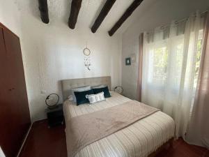 a bedroom with a bed with blue pillows and a window at Villa Mediterraneo in Tossa de Mar +37 photos
