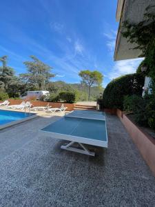 a ping pong table sitting on the ground next to a pool at Villa Mediterraneo in Tossa de Mar