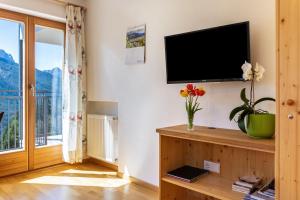 a living room with a flat screen tv on a wall at Thusnelda Apartment C in Siusi