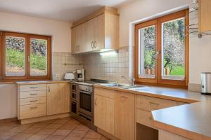 a large kitchen with wooden cabinets and windows at Thusnelda Apartment C in Siusi
