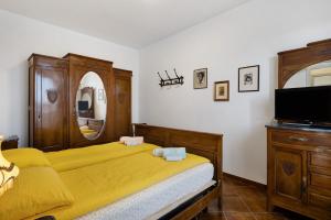 a bedroom with two beds and a tv and a mirror at Casa Dello Zio Birba in Portacomaro