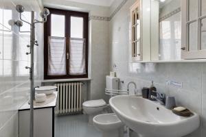 a white bathroom with a sink and a toilet at Casa Dello Zio Birba in Portacomaro +25 photos