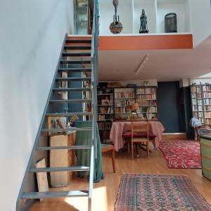 a staircase leading up to a room with bookshelves at La Musicale in Rouen