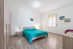 a bedroom with a green bed and a window at Villa Fontane Bianche with pool in Fontane Bianche +43 photos