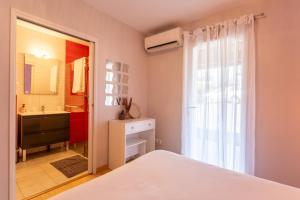 a bedroom with a bed and a bathroom with a sink at Chambre - Orchis in Aroue
