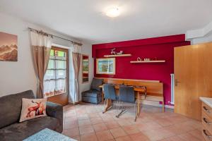 a living room with a red accent wall at Appartamenti Camilla in Canazei