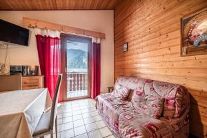 a bedroom with a couch and a window in a room at La Flèche d'Or in Châtel