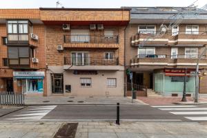 an empty street in front of a brick building at Pensado Para ti in Pozuelo de Alarcón