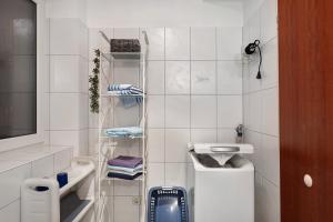 a small white tiled bathroom with a sink at Aufblühen in Menzenschwand in St. Blasien +27 photos