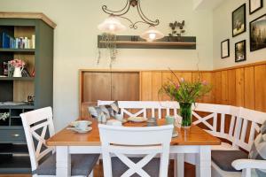 a dining room with a wooden table and white chairs at Aufblühen in Menzenschwand in St. Blasien