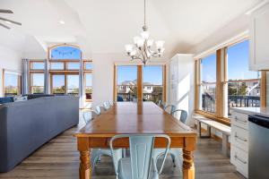 a kitchen and dining room with a wooden table and chairs at 1345 - Amarissa by the Sea in Corolla
