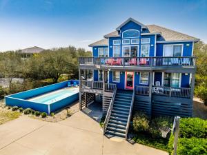 a blue house with a swimming pool in front of it at 1345 - Amarissa by the Sea in Corolla