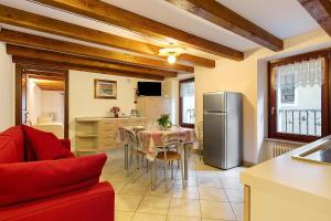 a kitchen and dining room with a table and a refrigerator at Le Bourg 61 - Aosta Centro in Aosta