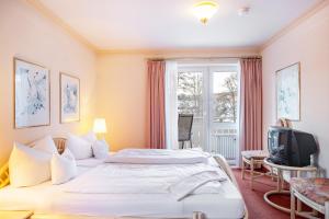 a hotel room with a bed and a tv at Ferienhaus Adler Bellevue in Hinterzarten