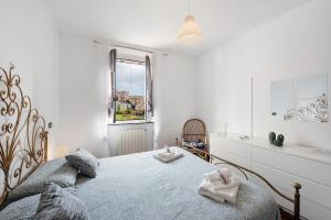 a white bedroom with a large bed with two towels at Mela Garden House in Genoa +30 photos
