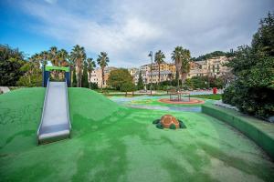 a playground with a slide and a turtle on the grass at Mela Garden House in Genoa