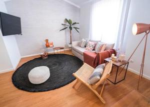 a living room with a couch and a large rug at Quinta da Romã in Olhão