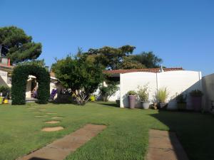 a yard with an arch and a lawn with plants at Sweet Home - Gujan-Mestras in Gujan-Mestras
