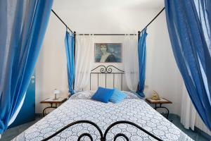 a bedroom with a bed with blue curtains at La Ripa - Appartamento Il Fienile in San Gimignano +22 photos