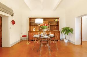 a dining room with a table and chairs and a book shelf at Villa Toscana a Fiesole in Florence +12 photos