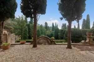 a garden with trees and a stone bench at Villa Toscana a Fiesole in Florence