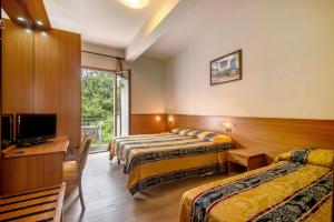 a hotel room with two beds and a television at Appartamento Bilocale Moneglia 22 in Moneglia +22 photos