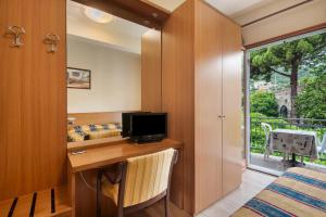 a bedroom with a desk with a television and a window at Appartamento Bilocale Moneglia 22 in Moneglia