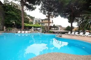 a swimming pool with chairs and a house in the background at Appartamento Bilocale Moneglia 22 in Moneglia