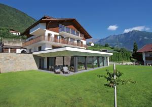 a large house on a hill with a green lawn at Ferienappartement Freiblick in Marlengo