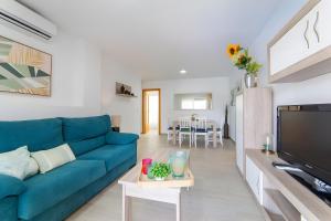 a living room with a blue couch and a tv at Calma Mar in Los Mártires