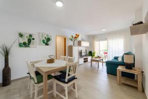 a kitchen and living room with a table and a blue couch at Calma Mar in Los Mártires
