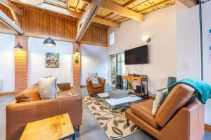a living room with leather furniture and a flat screen tv at Chambres D'hôtes Le Palmier in Sevremont