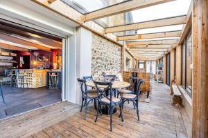 a patio with a table and chairs in a room at Chambres D'hôtes Le Palmier in Sevremont