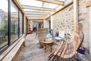 a patio with two benches and a stone wall at Chambres D'hôtes Le Palmier in Sevremont