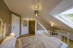 a attic bedroom with a bed and a window at Happy Hugle Haus in Offenburg