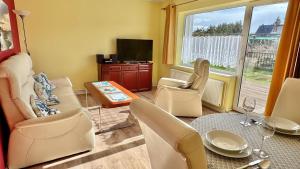 a living room with a table and chairs and a television at Haus Usedom in Kröslin