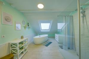 a bathroom with a white tub and a sink at Happy Hugle Haus in Offenburg +32 photos