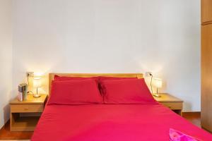 a bedroom with a red bed with two night stands at Cima de' Piazzi Apartment 1 in Valdidentro