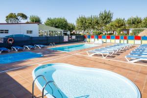 a swimming pool with lounge chairs and two pools at Bungalow A2 in Pontevedra