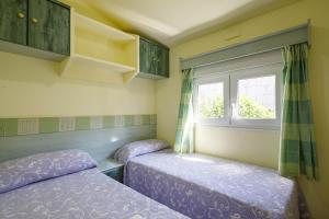 two beds in a room with a window at Bungalow A2 in Pontevedra +20 photos