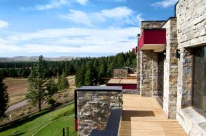 a house with a deck with a view of the mountains at Casa de Montaña Golf & Polo - San Martin de los Andes in San Martín de los Andes