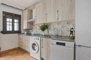 a kitchen with a sink and a washing machine at Mi Ilusión in Grazalema