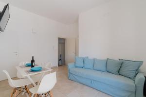 a living room with a blue couch and a table at Casa Anastasia in Otranto