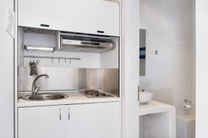 a kitchen with a sink and a microwave at Aegean Blue Santorini Perissa in Perissa +17 photos