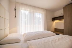 two beds in a bedroom with a window at Apartment Cinch Residence Bun Ste in San Vigilio Di Marebbe