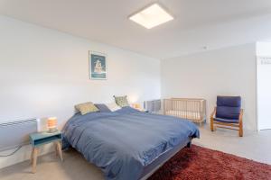 a bedroom with a large bed and a chair at Gîte Axeri Xilo in Saint-Martin-dʼArrossa