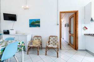a room with two chairs and a table and a kitchen at Casa Damiano 1935 in Villasimius +21 photos